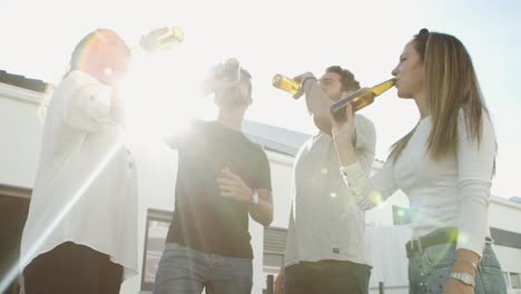 Entspannte-Freunde,-Die-Mit-Bierflaschen-Anstoßen-Und-Im-Freien-Tanzen
